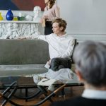 A counseling session in a modern office with a couple and a therapist discussing mental health.