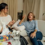 A counseling session with two women engaged in conversation on a comfortable sofa.